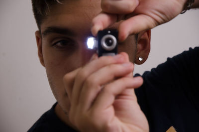 Close-up portrait of young man holding camera