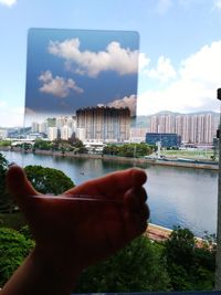 Cropped image of person by river against sky