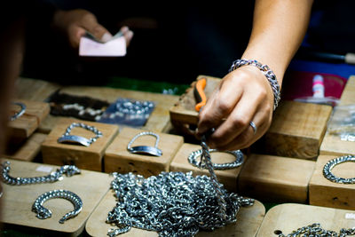 Midsection of men making bracelet