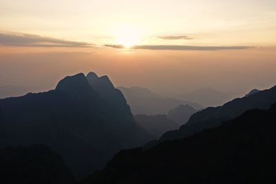 Scenic view of silhouette mountains against sky at sunset