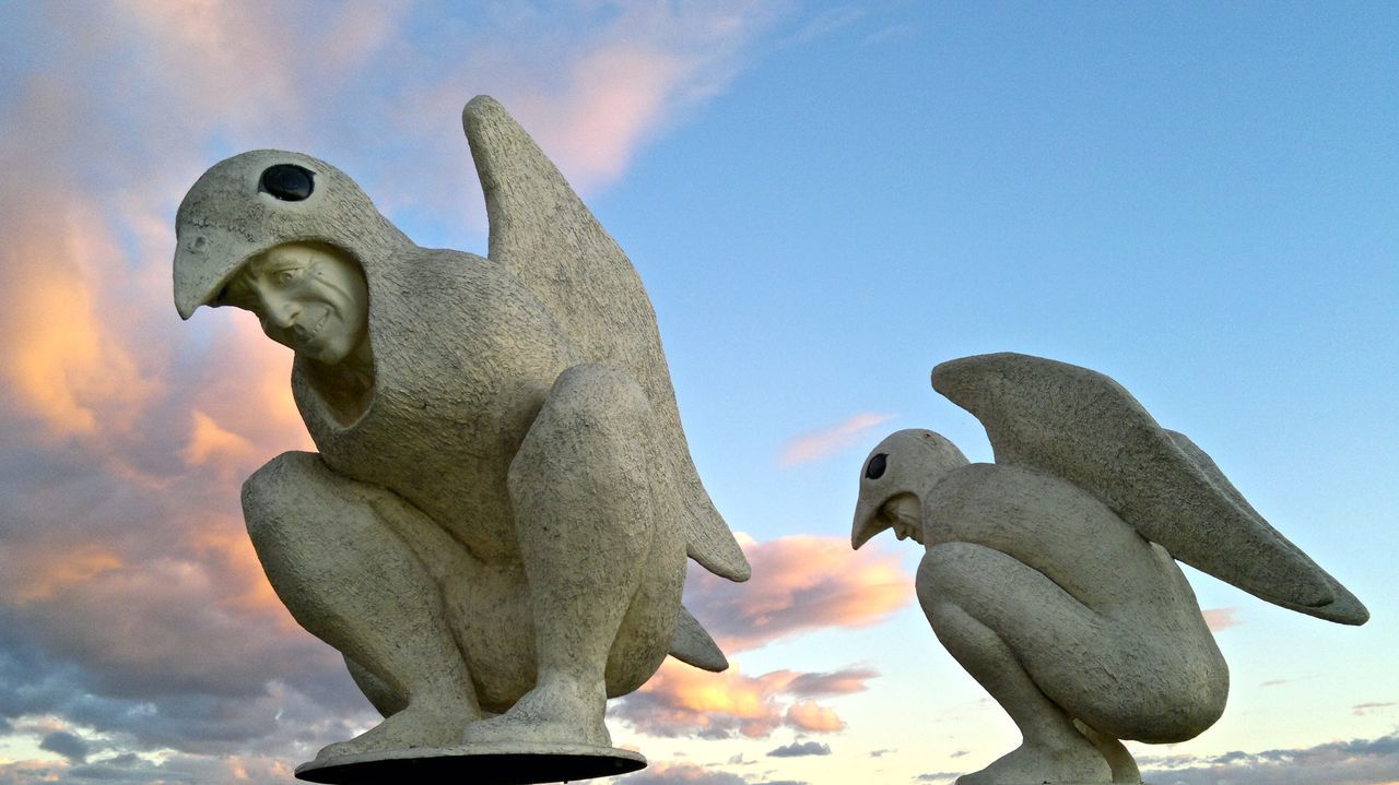 sculpture, sky, art and craft, statue, low angle view, animal themes, art, bird, animal representation, animals in the wild, wildlife, cloud - sky, creativity, human representation, outdoors, nature, blue, no people, day, close-up