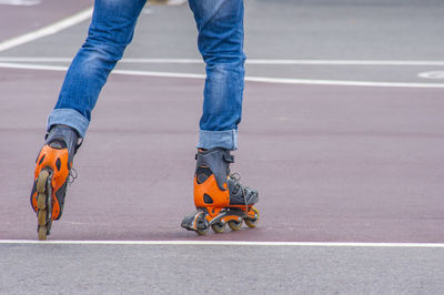 Low section of man inline skating on road