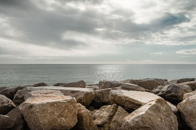 Rocks on sea shore against sky