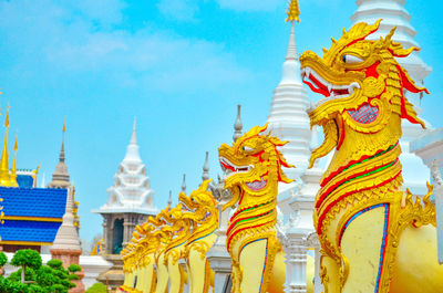 Low angle view of statues on building against sky