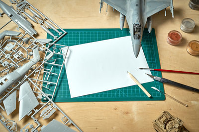 Top view on plastic model scale with accessories on green pad on bright wooden table