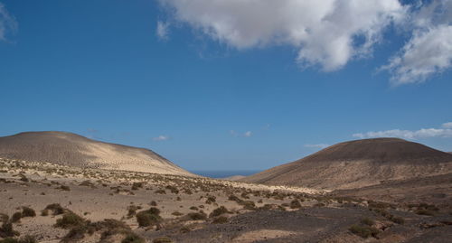 Scenic view of desert against blue sky