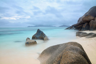 Scenic view of rocks on beach against sky