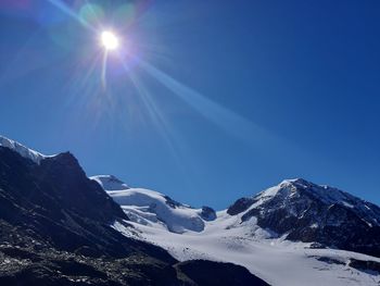 Scenic view of snowcapped mountains against blue sky