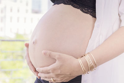 Midsection of woman touching mirror