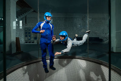 A man teaches a woman how to fly in a wind tunnel. free fall simulator