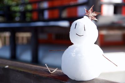 Close-up of snowman on wooden retaining wall