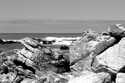 Scenic view of rocks on beach against sky