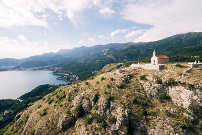 Panoramic view of buildings and mountains against cloudy sky