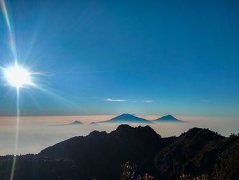 Scenic view of silhouette mountains against blue sky