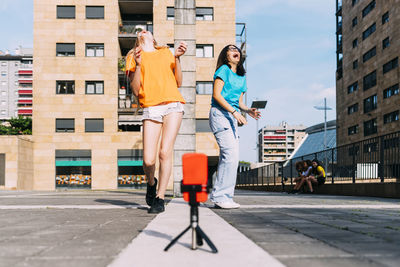 Cheerful girls vlogging enjoying on sunny day