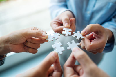 Midsection of man playing jigsaw puzzle