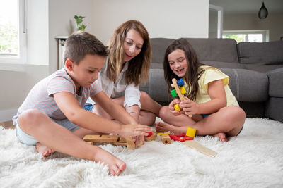 Portrait of siblings playing with daughter at home