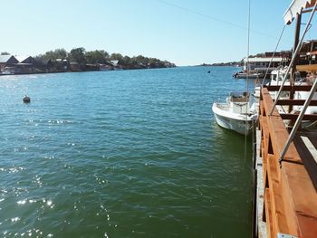 Sailboats moored on sea against clear sky