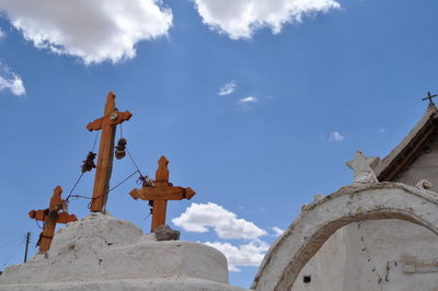 Low angle view of crosses against sky