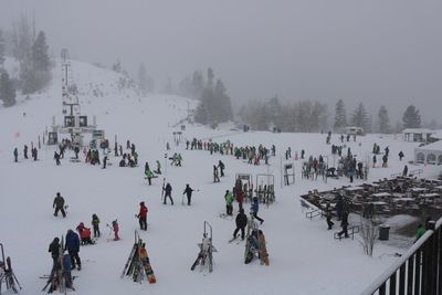 High angle view of people skiing on snow covered field