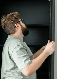 Young man looking through window