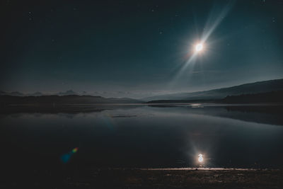 Scenic view of lake against sky at night