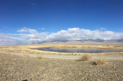 Scenic view of desert against blue sky