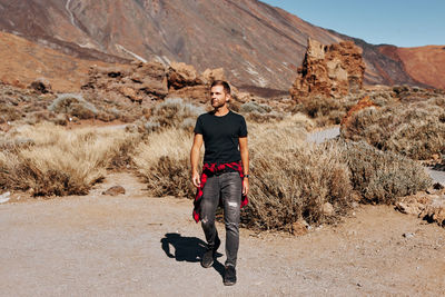 Full length of man walking on land against mountain