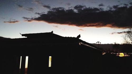 Low angle view of silhouette building against sky