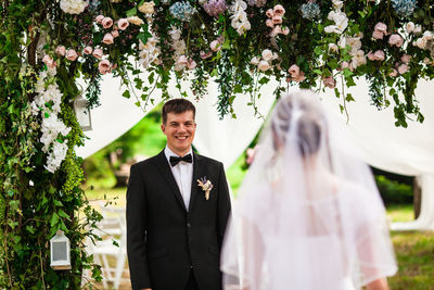 Couple standing on footpath by flowering plants