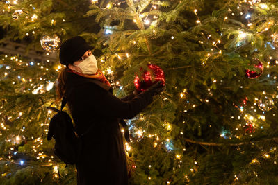 Young man in illuminated christmas tree