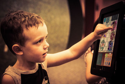 Close-up of boy touching digital display of device