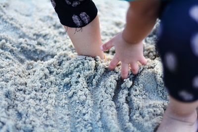 Midsection of person in sand at beach