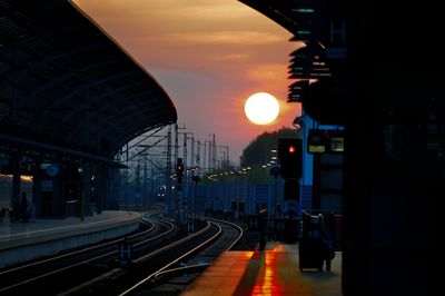 Train at railroad station during sunset