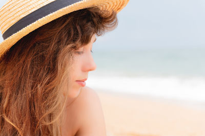 Close-up of woman wearing hat at beach