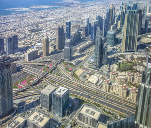 High angle view of illuminated street amidst buildings against sky