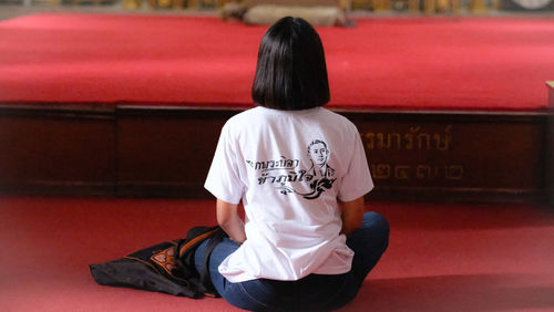 Rear view of woman sitting at home