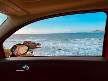 Scenic view of sea seen through car window