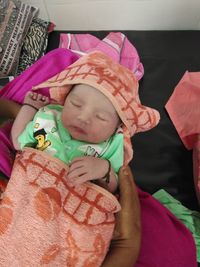 High angle view of cute baby sleeping on bed