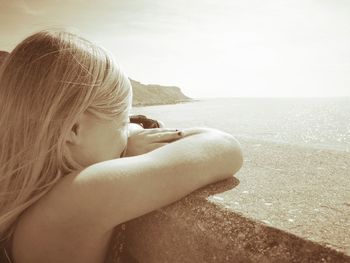 Close-up of child on beach against clear sky