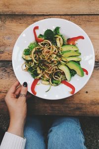 High angle view of woman eating noodles at table