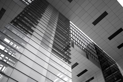 Low angle view of modern glass building against sky