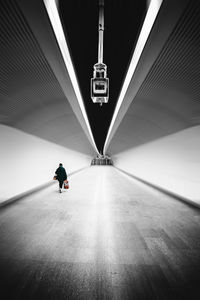 Rear view of man walking in illuminated building