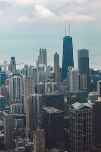 Modern buildings in city against cloudy sky