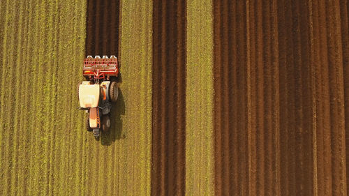 Farmer in tractor preparing land with seedbed cultivator in farmlands. tractor plows a field. 