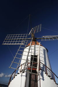 Low angle view of traditional windmill against blue sky