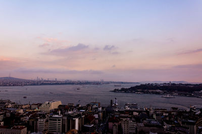 High angle view of townscape by sea against sky during sunset