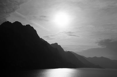 Scenic view of sea and silhouette mountains against sky