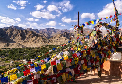 Colorful buntings hanging on mountain against sky