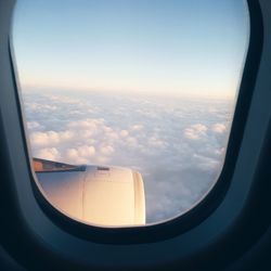 Aerial view of clouds over sea seen through airplane window